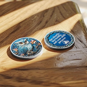 May include: Two round, decorative tokens. One features a blue owl illustration with the text "SEE CLEARLY, LIVE FREELY." The other has the text "See clearly, live boldly, and soar with purpose." Both have a silver border.