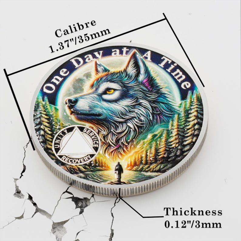May include: Silver-toned round coin with a colorful image of a wolf in a forest. The coin has the text "One Day at A Time" around the edge and a triangle with the words "Unity", "Service", and "Recovery" inside. The coin is 1.37 inches in diameter and 0.12 inches thick.