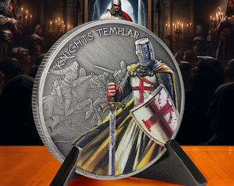 Könnte beinhalten: Eine silberne Münze mit der Darstellung eines Ritters in Rüstung, der ein Schwert und einen Schild hält. Die Münze steht auf einem schwarzen Ständer und hat die Aufschrift "Knights Templar" am Rand.