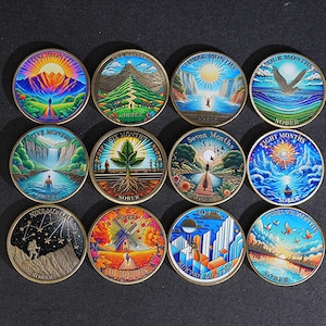 May include: Twelve colorful round coins with nature-themed designs, each representing a month. The coins feature illustrations of landscapes, people, and text such as "SOBER" and month numbers. The designs include mountains, waterfalls, and celestial elements.