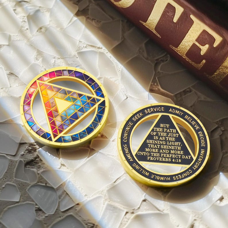 Puede incluir: Dos medallones circulares dorados. Uno presenta un dise&ntilde;o geom&eacute;trico colorido con un tri&aacute;ngulo en el centro. El otro tiene el texto "Pero el camino de los justos es como la luz brillante..." y otras frases.