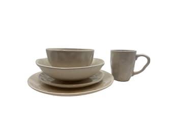 May include: A set of beige ceramic dishes, including a bowl, a smaller bowl, a plate, and a mug.