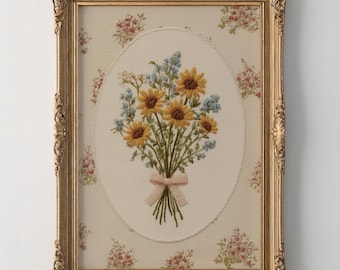 May include: A rectangular gold ornate frame containing a fabric panel with an embroidered bouquet of yellow sunflowers and blue flowers tied with a light pink ribbon. The background fabric features a repeating pattern of small pink floral clusters.