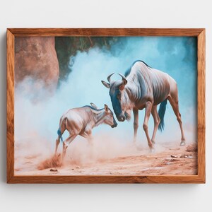 Può includere: Stampa incorniciata con due gnu in una scena desertica. Lo gnu adulto è azzurro con corna ricurve, mentre il vitello è marrone chiaro. Lo sfondo ha una tavolozza di colori blu e beige, con polvere e sabbia in primo piano.