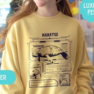 May include: A yellow sweatshirt with a graphic of a manatee and the text "MANATEE" and "TRICHECHUS". The sweatshirt has a "BUTTER" label and a "LUXURY FEEL" label.