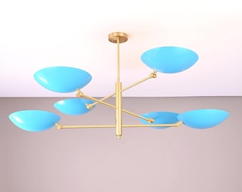 May include: A modern ceiling light fixture with six light blue, oval-shaped shades. The shades are attached to gold-colored arms extending from a central stem. The fixture is mounted on a gold-colored ceiling plate.