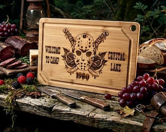 May include: A wooden cutting board with a carved design featuring a hockey mask, crossed knives, and the text "WELCOME TO CAMP CRYSTAL LAKE 1980". The board is surrounded by food items and knives.