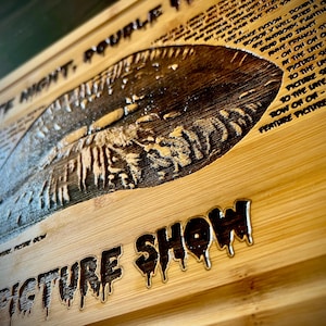 May include: Wooden sign with the words "LATE NIGHT, DOUBLE FEATURE PICTURE SHOW" carved into the wood. The sign has a vintage, horror movie theme with dripping font and a detailed image.