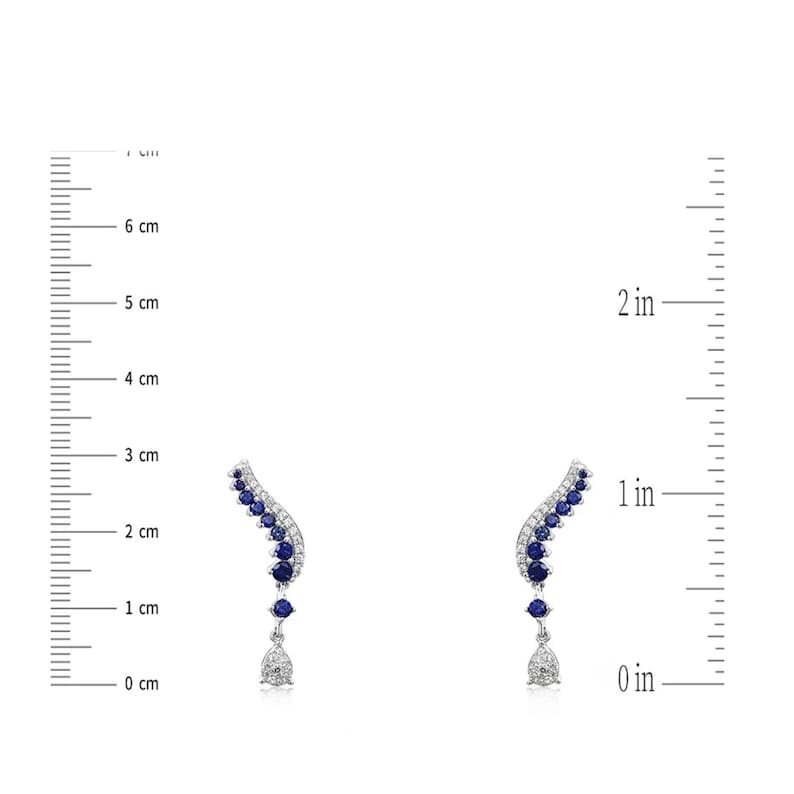 Puede incluir: Un par de pendientes plateados con un dise&ntilde;o curvo. Cada pendiente presenta una fila de piedras preciosas azules y un colgante en forma de l&aacute;grima. Los pendientes miden aproximadamente 2.5 cm de largo.