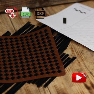 Könnte beinhalten: Ein braunes und schwarzes kariertes Lederstück mit PDF-, CDR- und DXF-Dateisymbolen. Ein weißes Papier mit einem Design befindet sich im Hintergrund. Ein Videosymbol befindet sich in der unteren rechten Ecke.