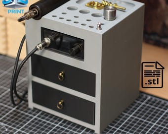 May include: A gray 3D print station with a black control panel, two black drawers with gold handles, and a top surface with various holes and metal components. A black cable and a 3D print tool are attached. The image includes the text "3D PRINT" and a .stl file icon.