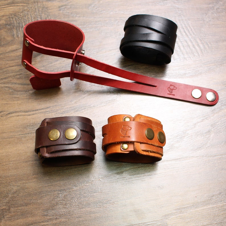 May include: Four leather bracelets, two brown, one red and one black. The bracelets are all different styles and have metal accents.