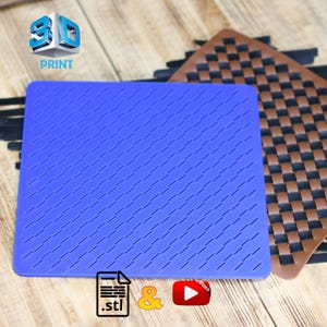 May include: A blue rectangular silicone mat with a diagonal grooved pattern. A brown woven mat is partially visible in the background. The image also includes the text "3D PRINT" and icons for .stl, an ampersand, and a video play button.