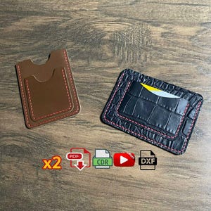 Op de afbeelding: Twee leren kaarthouders, één bruin en één zwart, worden getoond op een houten oppervlak. De bruine kaarthouder heeft een gladde textuur met rode stiksels. De zwarte kaarthouder heeft een krokodillenleertextuur met rode stiksels. Beide hebben meerdere vakken.