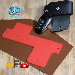 Könnte beinhalten: Ein roter, 3D-gedruckter Schlüsselanhänger mit der Aufschrift "General key cover V1" neben einem Autoschlüssel und einem schwarzen Leder-Schlüsselhalter. Das Bild zeigt auch ein "3D PRINT"-Logo, ein Dateisymbol und ein Videosymbol.