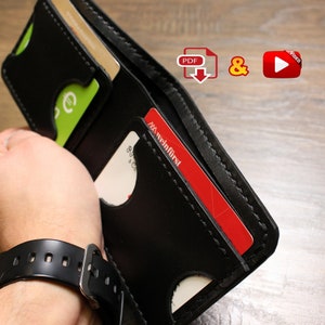 Könnte beinhalten: Schwarzes Lederportemonnaie mit mehreren Kartenfächern und einem genähten Design. Das Portemonnaie ist geöffnet und zeigt eine rote Kreditkarte mit dem Text "XXX weinfirst" und eine grüne Karte mit einem Euro-Symbol.