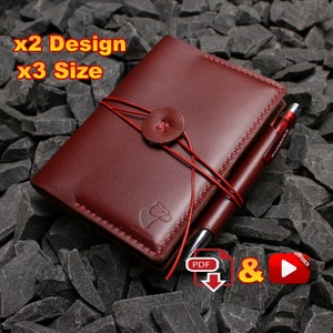 Può includere: Un taccuino in pelle color bordeaux con chiusura a bottone e una penna al suo interno. Il taccuino è legato con un cordoncino rosso e ha un piccolo logo di un orso in rilievo sul davanti. Il testo "x2 Design x3 Size" è visibile nell'angolo in alto a sinistra dell'immagine. Le parole "PDF" e "VIDEO" sono visibili nell'angolo in basso a destra dell'immagine.