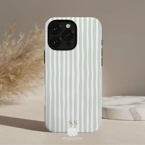 May include: A phone case with a vertical striped pattern in light green and white. The case has a black camera module and side buttons. The bottom of the case features the initials "S.S" and the text "DESIGNS BY CONIE".