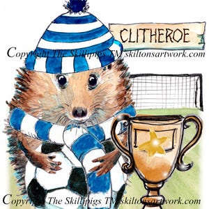 Pode incluir: Ilustração de cartão de aniversário com um ouriço com chapéu e cachecol listrados em azul e branco, segurando uma bola de futebol. Um troféu dourado e a palavra "Clitheroe" também estão presentes. O texto "Happy Birthday" está no topo.