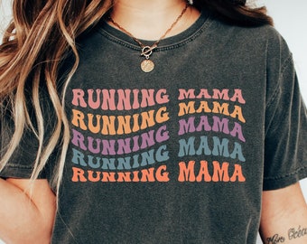 May include: A dark gray t-shirt with the text "RUNNING MAMA" repeated five times in a rainbow of colors. The text is in a retro font style.