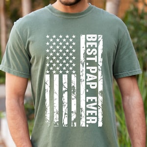 May include: A green t-shirt with a distressed white American flag design and the text "BEST. PAP. EVER."