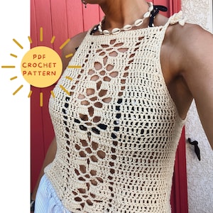 May include: A cream-colored sleeveless crochet top featuring an intricate openwork pattern with tie-up shoulder straps. A yellow graphic icon on the left displays the text PDF CROCHET PATTERN. The top is worn over a black and white polka dot bikini top.