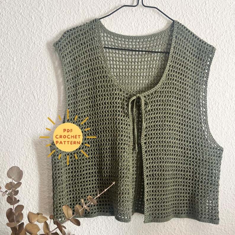 Op de afbeelding: Een groene gehaakte vest met een strik sluiting. De vest is gemaakt met een eenvoudig steekpatroon en heeft een losse pasvorm. De afbeelding bevat de tekst "PDF CROCHET PATTERN".