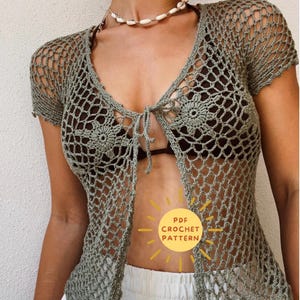 Op de afbeelding: Een gehaakt topje met een strik aan de voorkant en een delicaat opengewerkt patroon. Het topje is lichtgroen en heeft korte mouwen. De tekst "PDF CROCHET PATTERN" is zichtbaar in de afbeelding.