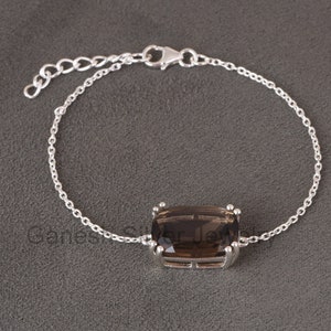 May include: A silver chain bracelet featuring a large, rectangular, smoky quartz gemstone. The gemstone is set in a silver bezel.