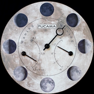 Puede incluir: Un reloj redondo con un diseño de fases lunares. El reloj presenta una esfera central con manecillas, rodeada de ilustraciones de las fases de la luna. La palabra "FUCAMA" está impresa en la esfera del reloj. También se muestran las palabras "Waning" y "Waxing".