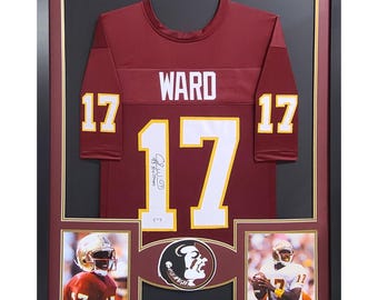 May include: A framed burgundy football jersey with the name "WARD" and the number "17" on the front. The jersey is signed by the player. The frame includes three smaller photos of the player in action.