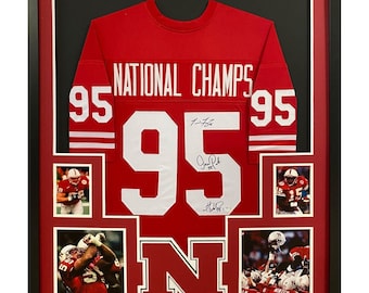 Camiseta firmada y enmarcada del Campeonato Nacional de Nebraska (PSA/DNA) de 1995