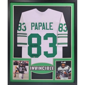 May include: A framed white football jersey with the number 83 and the name "PAPALE" in green lettering. The jersey is signed by "Vince Papale" and includes a photo of Papale in a Philadelphia Eagles uniform.