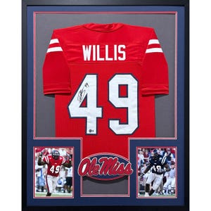 May include: Framed red football jersey with the name "WILLIS" and the number "49" in white. The jersey is signed and displayed with two action shots of a player in a football uniform and the "Ole Miss" logo.