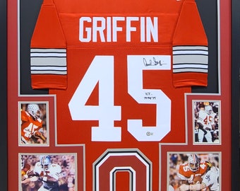 May include: A framed red football jersey with the name "GRIFFIN" and the number "45" on the back. The jersey is signed by the player. The frame includes four smaller photos of the player in action.