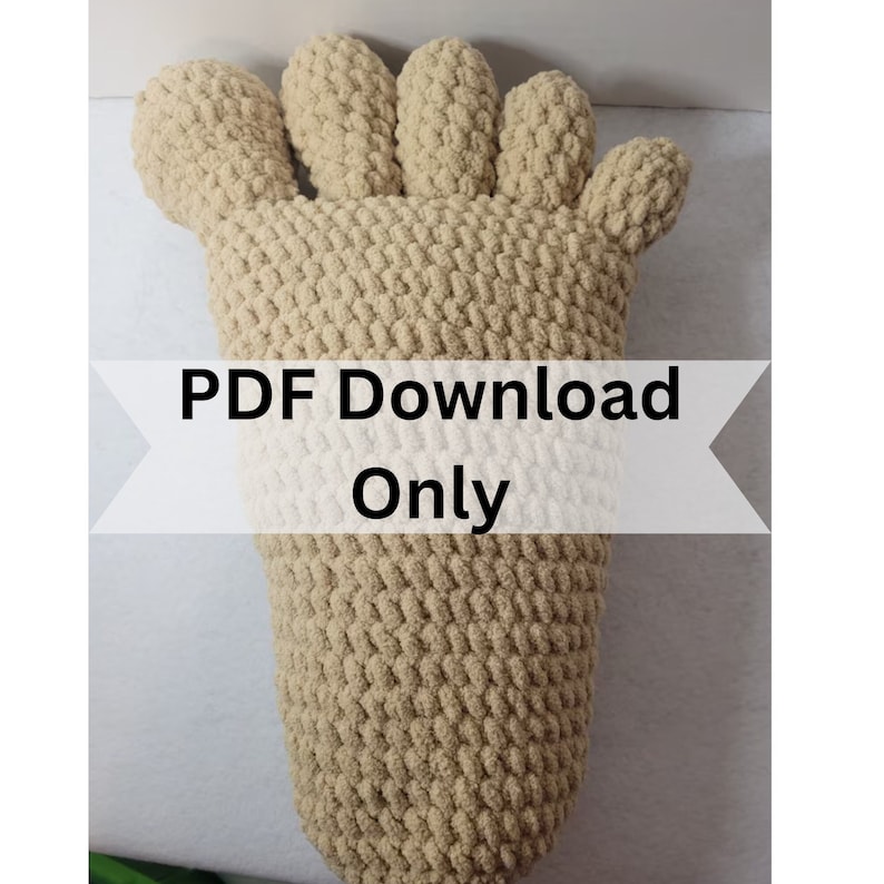 May include: A crocheted foot-shaped pillow in a beige color. The pillow has five toes and is made with a textured stitch. The text "PDF Download Only" is printed on a white banner.