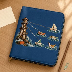 Puede incluir: Una carpeta azul oscuro con cremallera que presenta una ilustración detallada de un faro en una costa rocosa, con haces de luz que conectan varios barcos de papel y un pájaro de papel flotando sobre olas estilizadas en el agua.
