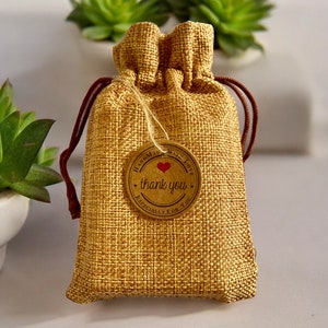 May include: A small burlap bag with a brown drawstring and a round brown tag that says "Handmade with Love, thank you, Especially for you". The tag has a red heart in the center.