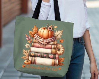 May include: A green tote bag with a stack of books, a pumpkin, and fall leaves. The text "all booked for fall" is printed on the bag.