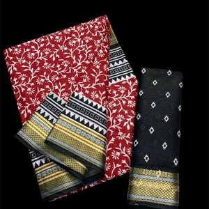 Pu&ograve; includere: Un sari stampato con fiori rossi e bianchi con un bordo nero e bianco e una blusa stampata in nero e bianco. Il sari ha un bordo dorato e argentato.