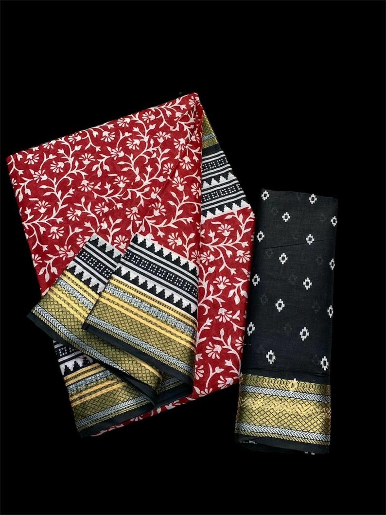 Pu&ograve; includere: Un sari stampato con fiori rossi e bianchi con un bordo nero e bianco e una blusa stampata in nero e bianco. Il sari ha un bordo dorato e argentato.