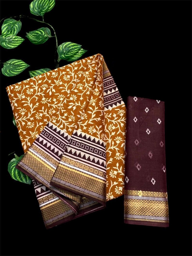 Pu&ograve; includere: Un sari stampato con fiori marroni e bianchi con un bordo marrone e bianco. Il sari ha una blusa marrone abbinata con un motivo geometrico bianco.