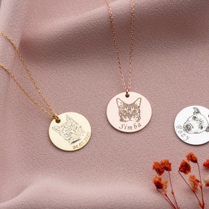 Puede incluir: Tres collares personalizados con retratos de mascotas grabados. Un collar dorado presenta un retrato de gato con la fecha 04.05.2020. Un collar de oro rosa muestra un retrato de gato con el nombre "Simba". Un collar plateado muestra un retrato de perro con el nombre "Rozy".