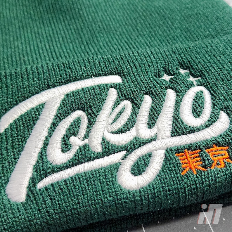 May include: Green beanie with white embroidered text that says "Tokyo" and orange embroidered text that says "東京".