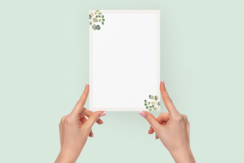 May include: A rectangular white card with a decorative border and watercolor eucalyptus leaf accents in the corners. The card is held by two hands against a light green background.