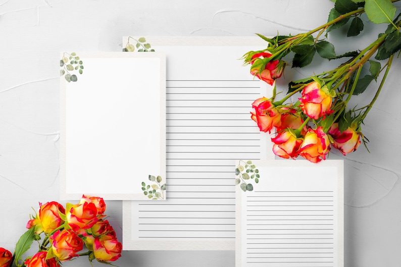 May include: White stationery with eucalyptus accents and lined pages. A bouquet of orange and yellow roses with green leaves is arranged on the side. The stationery is perfect for writing letters or notes.