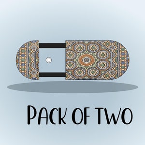 Peut inclure: Un lot de deux sous-verres décoratifs en carrelage avec un motif géométrique dans des tons de bleu, orange et marron. Les sous-verres sont en forme de pilule et ont une bordure noire. Le texte "PACK OF TWO" est imprimé sous les sous-verres.