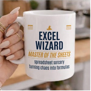 Puede incluir: Taza de cerámica blanca con el texto "EXCEL WIZARD MASTER OF THE SHEETS" en azul marino y dorado. La taza también presenta un icono de sombrero de mago y la frase "spreadsheet sorcery turning chaos into formulas".