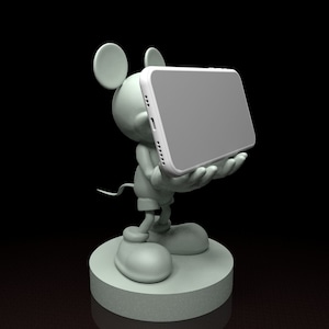 Puede incluir: Una estatua verde claro de un ratón de dibujos animados sosteniendo un teléfono inteligente blanco. El ratón está de pie sobre una base redonda sobre un fondo negro. El teléfono inteligente tiene una pantalla gris.