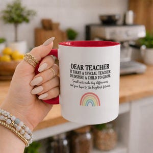 Peut inclure: Un mug en céramique blanche avec un intérieur et une anse rouges. L'avant présente un texte noir qui dit : Dear Teacher, it takes a special teacher to inspire a child to grow. Small acts make big differences and give hope to the brightest futures.